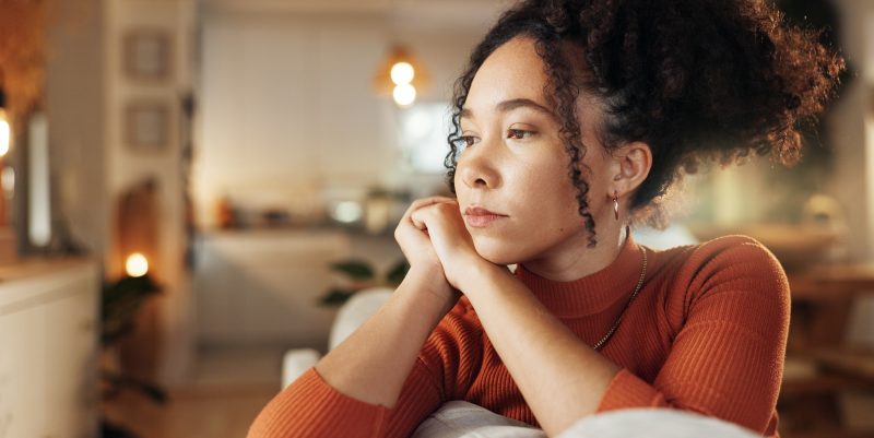 Mujer pensativa con expresión seria.